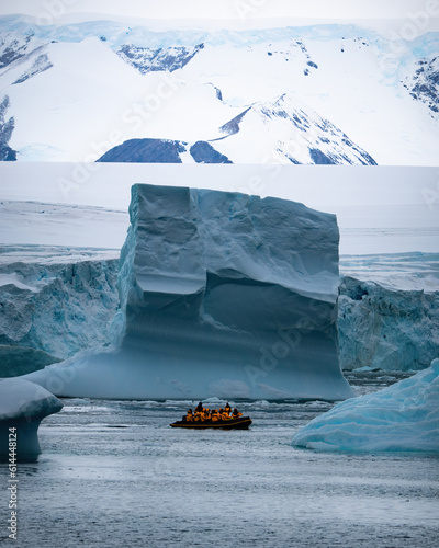 Boat full of tourists explore huge icebergs drifting in the bay near Ilulissat greenland arctic, Antarctic peninsula