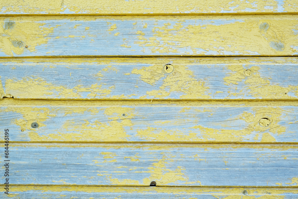 Obraz premium The texture of cracked yellow paint on a wooden wall
