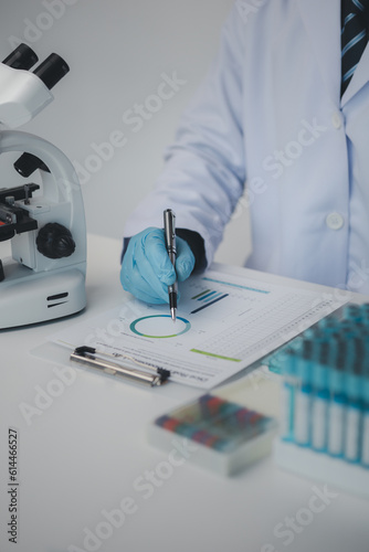 Lab assistant, medical scientist, chemistry researcher holds a glass tube through a chemical test tube, does a chemical experiment and examines a patient's sample. Medicine and research concept.