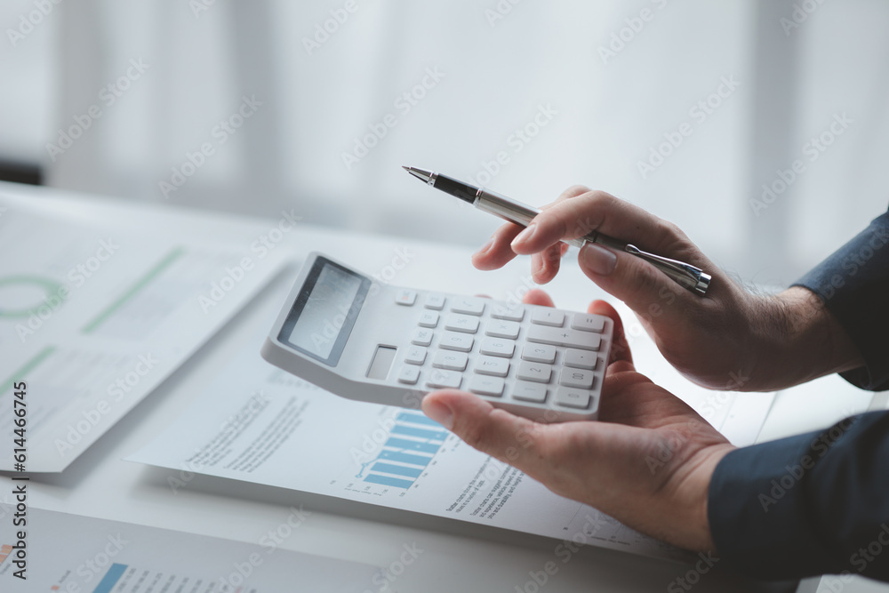 Businessman in a private office at his company and is reviewing company financial documents, senior management checking financial information for accuracy. Financial management.