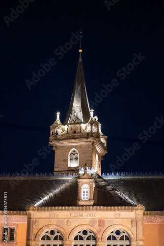 Obraz na płótnie Obernai après le coucher du soleil: Horloge et emblème en lumière w salonie