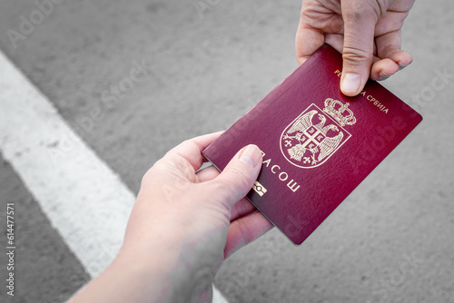 Giving a National passport of Serbia for a check on the boarder. No face, hands