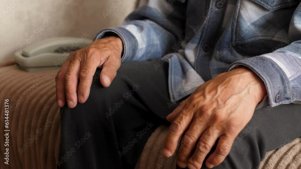 a pensioner sitting at home near a landline wired telephone waiting for a call from a close relative. emotions of the elderly. a lonely pensioner is bored a pensioner sitting at home near a landline wired telephone waiting for a call from a close relative. emotions of the elderly. a lonely pensioner is bored