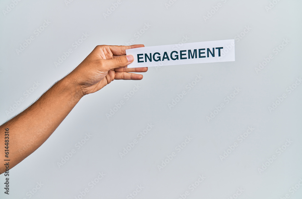 Hand of caucasian man holding paper with engagement word over isolated white background