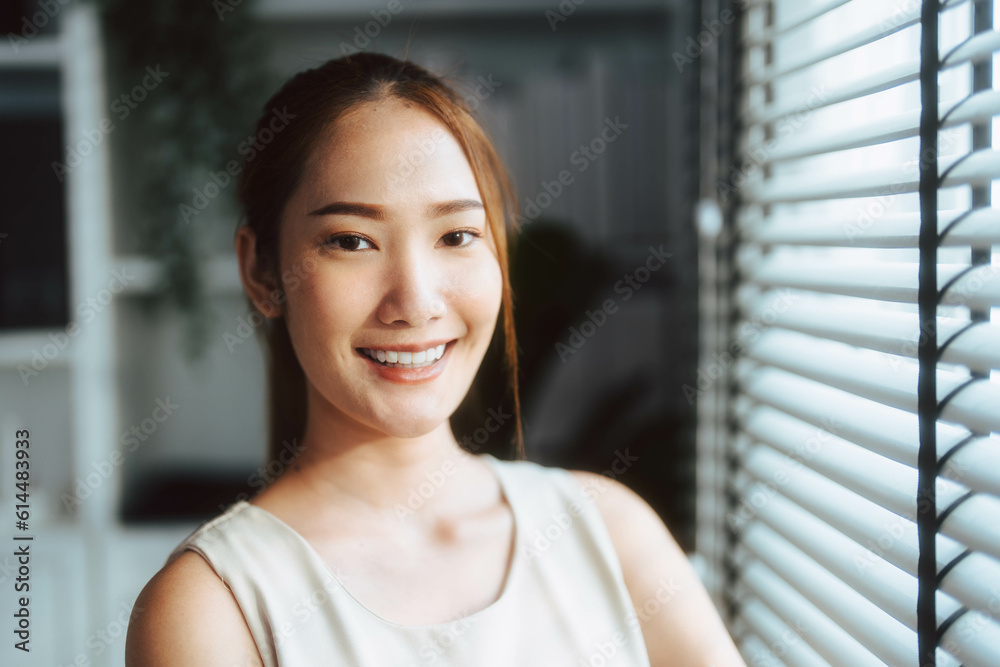 Portrait of Asian woman smiling while looking at camera.