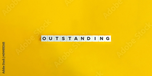 Outstanding Word on Block Letter Tiles on Yellow Background. Minimal Aesthetic.