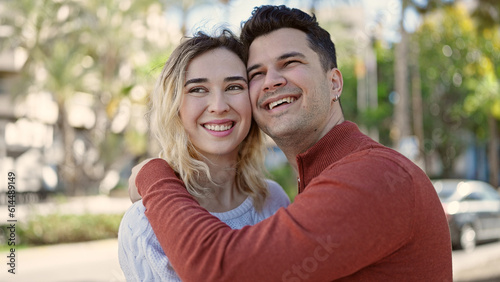 Man and woman couple smiling confident hugging each other at park