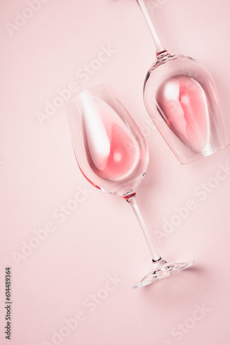 Two glasses of rose wine on a pink background.