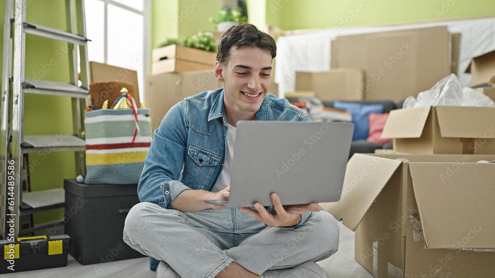 Young hispanic man using laptop sitting on floor at new home Young hispanic man using laptop sitting on floor at new home