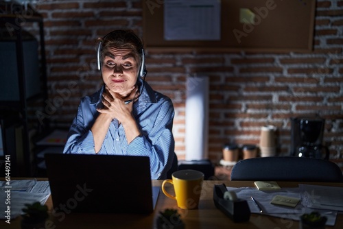 Beautiful brunette woman working at the office at night shouting and suffocate because painful strangle. health problem. asphyxiate and suicide concept.