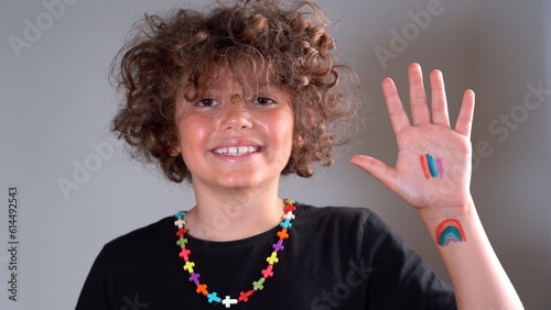Boy kid 9 years old with rainbow freedom flag in hands - lgbt sign gay pride - rights of homosexual couples and recognition of adopted children