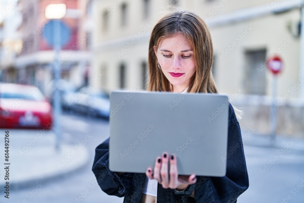 Young blonde woman using laptop at street Young blonde woman using laptop at street