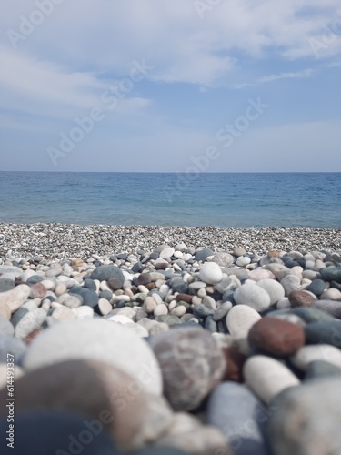 Image of deep blue sea and cloudy sky and pebbles