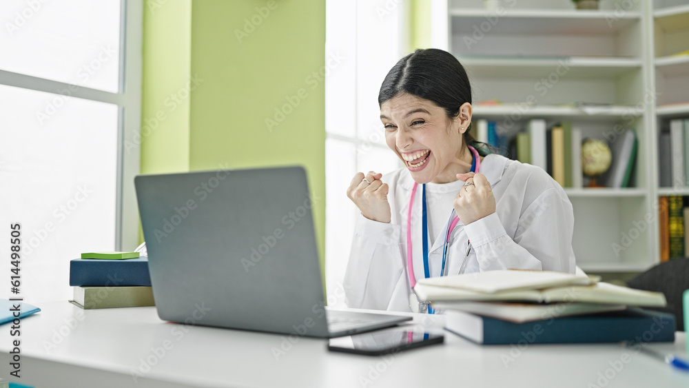 Young beautiful hispanic woman doctor having video call with winner expression at library university Young beautiful hispanic woman doctor having video call with winner expression at library university