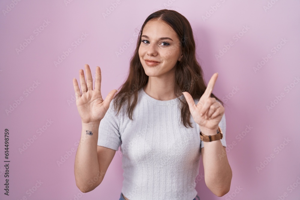 Young hispanic girl standing over pink background showing and pointing up with fingers number seven while smiling confident and happy. Young hispanic girl standing over pink background showing and pointing up with fingers number seven while smiling confident and happy.