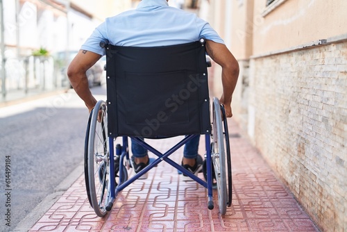 Young latin man sitting on wheelchair at street photo