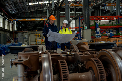 Technical staff together with engineers inspect the structure of the electric train's propulsion system in order to maintain the electric train in the depot.