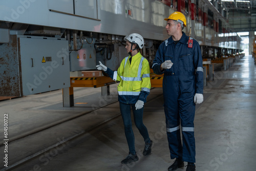 The technicians together with the engineers inspect the structure of the train propulsion system to maintain the trains in the depot.