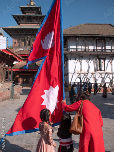 Durbar square, Nepal. Newari family with Nepal national flag at main square.