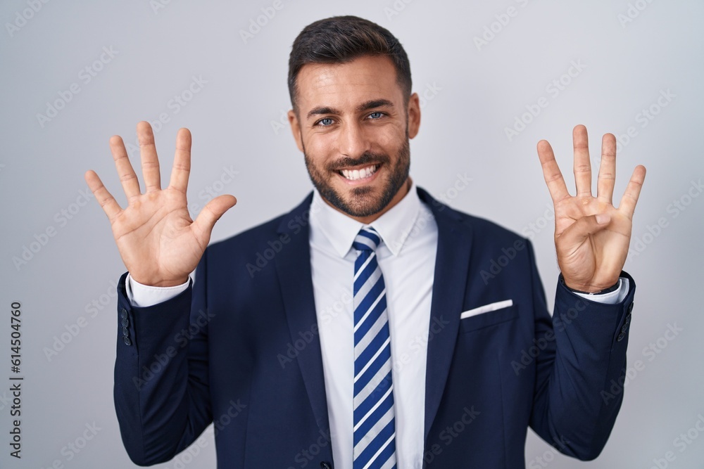 Handsome hispanic man wearing suit and tie showing and pointing up with fingers number nine while smiling confident and happy. Handsome hispanic man wearing suit and tie showing and pointing up with fingers number nine while smiling confident and happy.