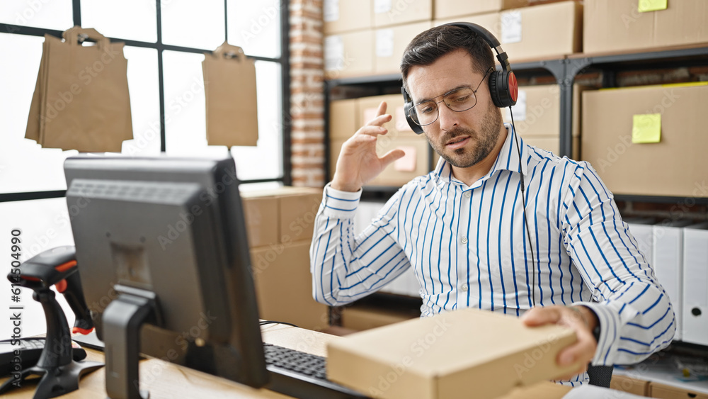 Fototapeta premium Young hispanic man ecommerce business worker having video call holding package at office
