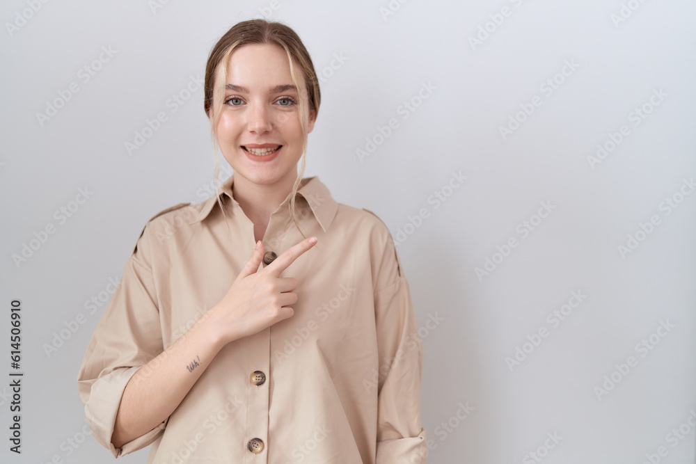 Young caucasian woman wearing casual shirt cheerful with a smile on face pointing with hand and finger up to the side with happy and natural expression Young caucasian woman wearing casual shirt cheerful with a smile on face pointing with hand and finger up to the side with happy and natural expression
