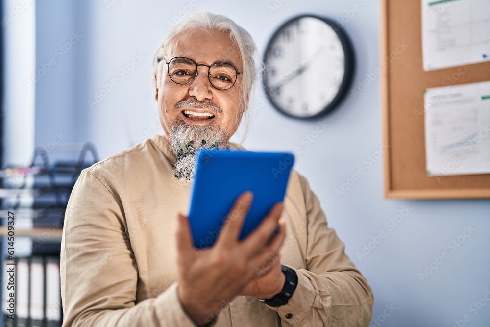 Middle age grey-haired man business worker smiling confident using touchpad at office Middle age grey-haired man business worker smiling confident using touchpad at office