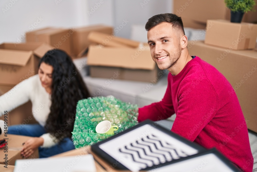 Man and woman couple smiling confident packing packages at new home Man and woman couple smiling confident packing packages at new home