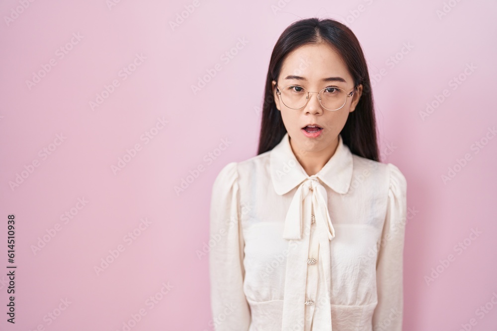 Young chinese woman standing over pink background afraid and shocked with surprise expression, fear and excited face. Young chinese woman standing over pink background afraid and shocked with surprise expression, fear and excited face.