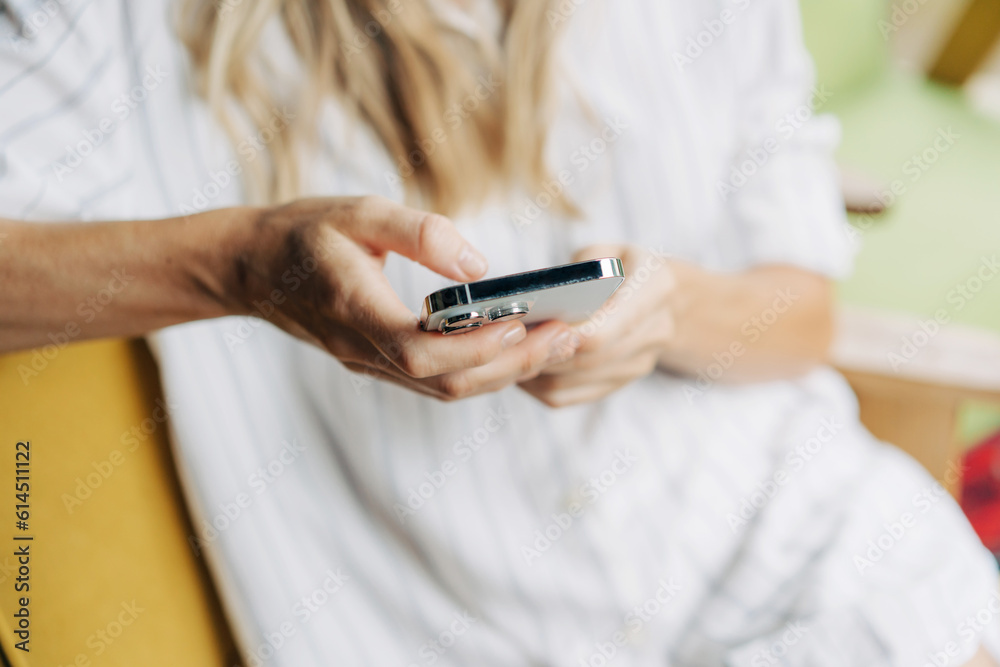 Close-up of a woman holding a mobile phone and typing a message on the touch screen. Close-up of a woman holding a mobile phone and typing a message on the touch screen.