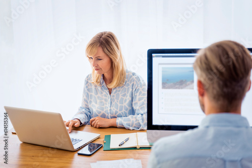 Businesswoman and businessman using computer and laptop for work