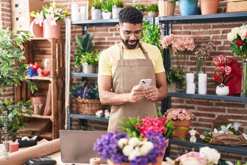 Young arab man florist make photo to plant by smartphone at florist