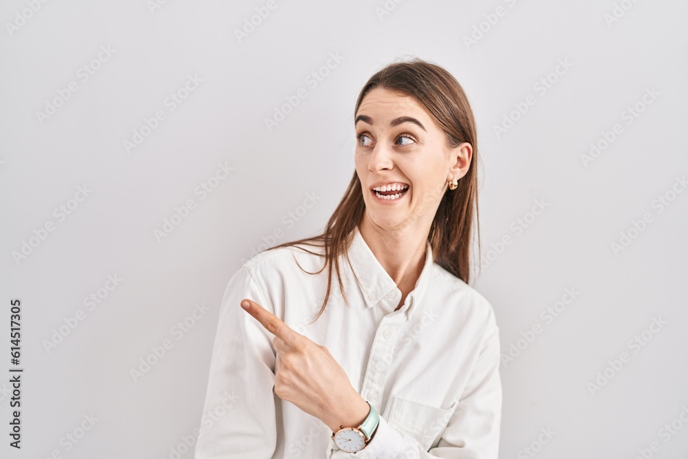 Young caucasian woman standing over isolated background pointing aside worried and nervous with forefinger, concerned and surprised expression Young caucasian woman standing over isolated background pointing aside worried and nervous with forefinger, concerned and surprised expression