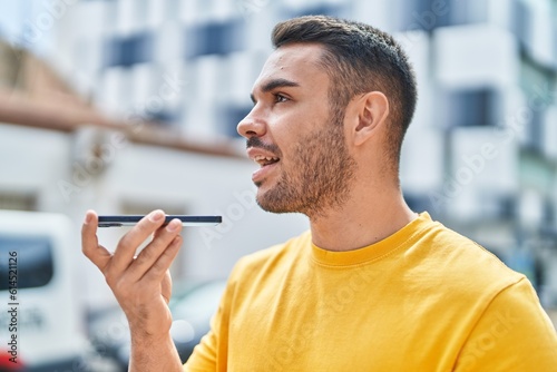 Young hispanic man smiling confident talking on the smartphone at street