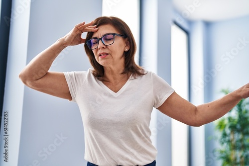 Middle age woman suffering dizzy standing at home photo