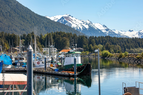 fishing boats moored in the docks in Sitka Alaska with scenic snowcapped mountains in the background  photo