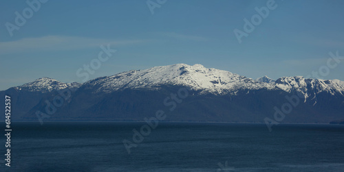 scenic landscape photograph of the snowcapped mountains of Alaska from the ocean view.