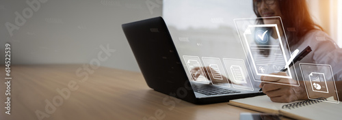 Businesswoman signs an electronic document on a digital document on a virtual notebook screen, Concept paperless workplace idea,e-signing, electronic signature, document management.
