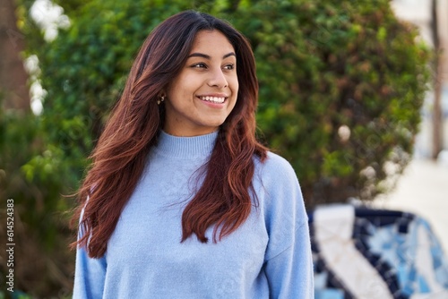 Young hispanic woman smiling confident standing at park