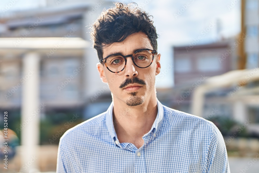 Young caucasian man standing with serious expression at street Young caucasian man standing with serious expression at street