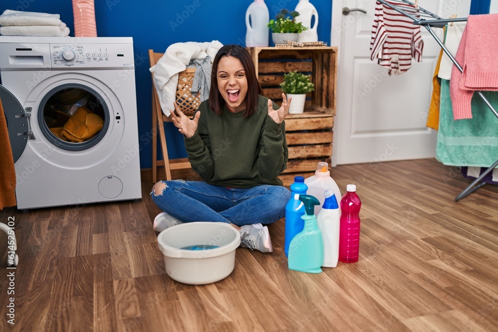 Young hispanic woman doing laundry washing by hand celebrating mad and crazy for success with arms raised and closed eyes screaming excited. winner concept Young hispanic woman doing laundry washing by hand celebrating mad and crazy for success with arms raised and closed eyes screaming excited. winner concept