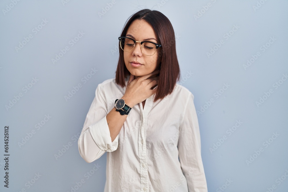 Young hispanic woman standing over white background touching painful neck, sore throat for flu, clod and infection Young hispanic woman standing over white background touching painful neck, sore throat for flu, clod and infection