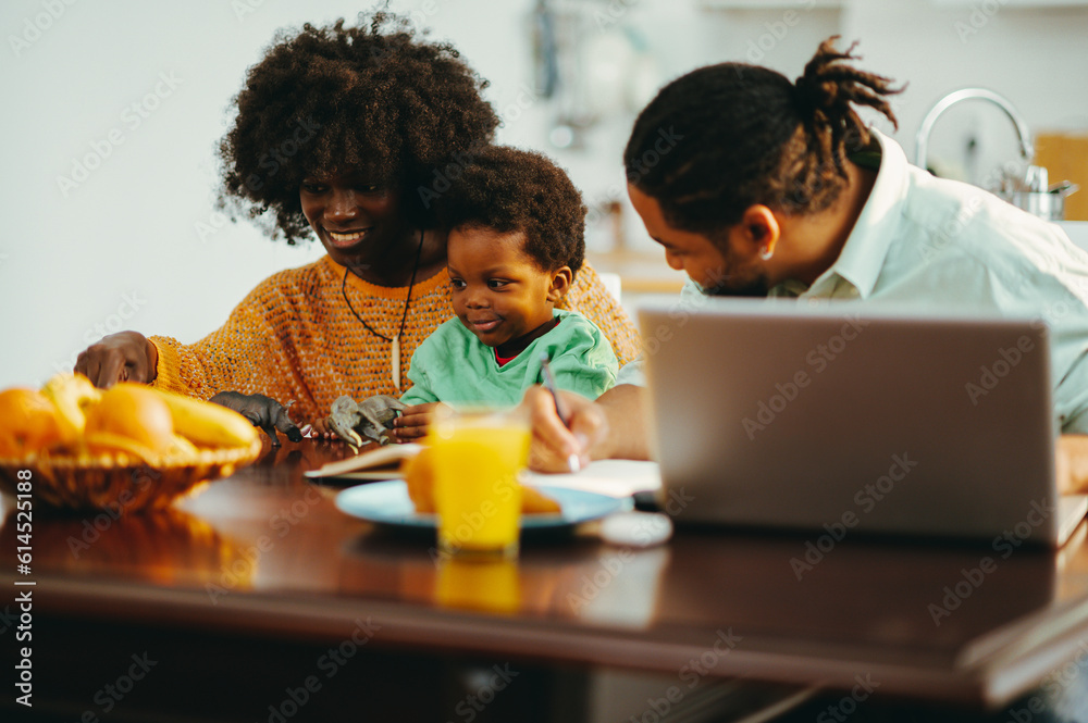 A happy multicultural family is sitting at home at the breakfast table and spending time together. A happy multicultural family is sitting at home at the breakfast table and spending time together.