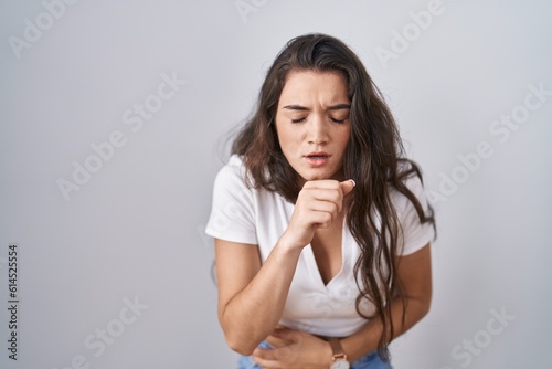 Young teenager girl standing over white background feeling unwell and coughing as symptom for cold or bronchitis. health care concept.