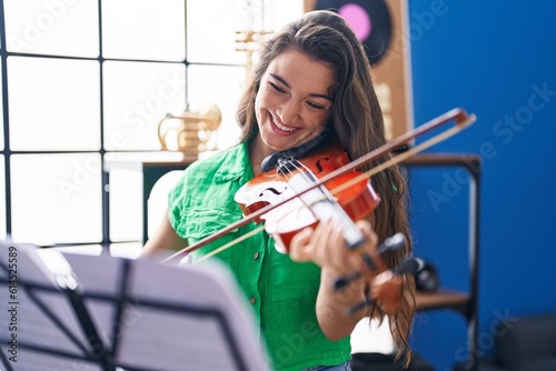Wallpaper Mural Young hispanic woman musician smiling confident playing violin at music studio