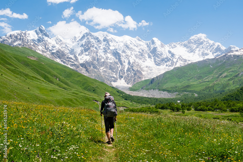 Tourist with a backpack in Caucasus mountains. Svaneti region, Georgia