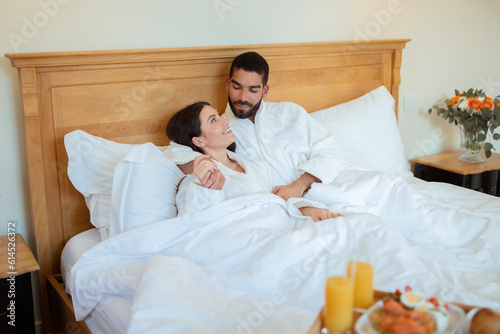 Loving Couple Hugging During Breakfast In Bed At Hotel Indoors
