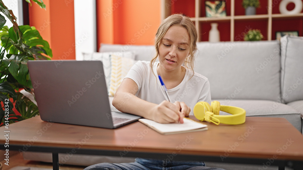 Young blonde woman having online class sitting on floor at home Young blonde woman having online class sitting on floor at home