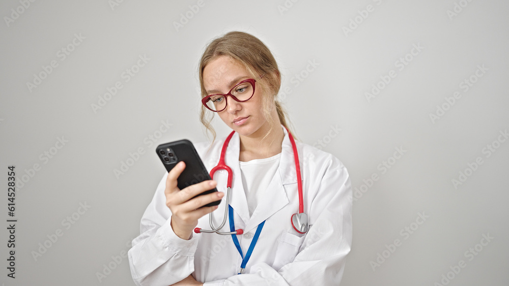 Young blonde woman doctor using smartphone over isolated white background Young blonde woman doctor using smartphone over isolated white background