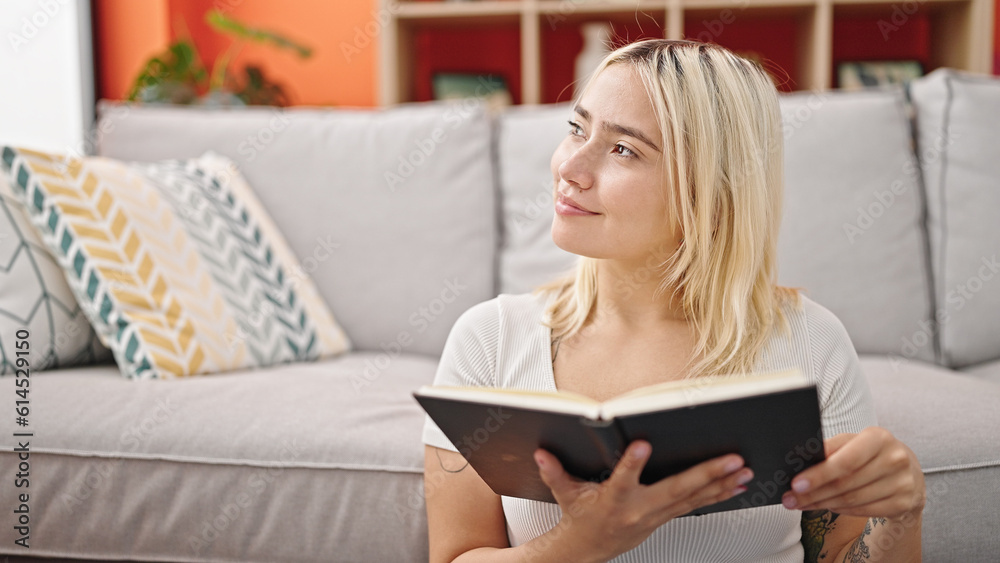 Young beautiful hispanic woman reading book sitting on floor at home Young beautiful hispanic woman reading book sitting on floor at home